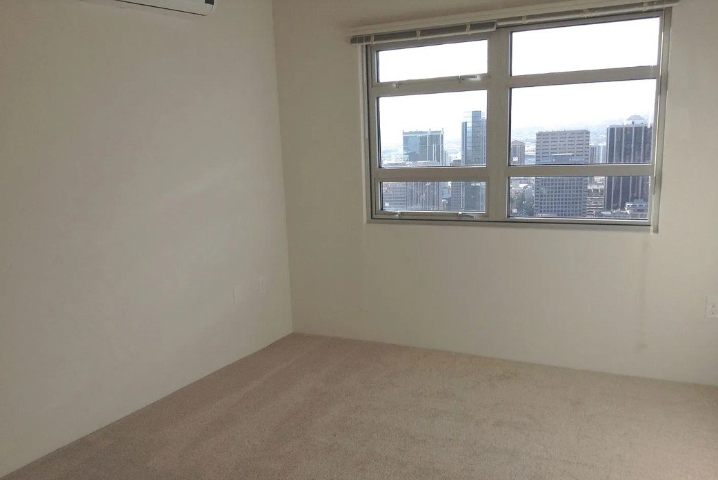 A room with a window overlooking a cityscape.